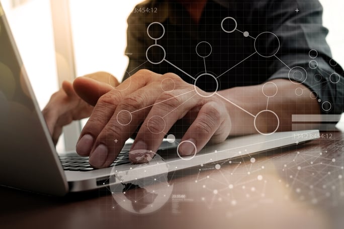 business man hand working on laptop computer on wooden desk with digital business layer effect diagram as concept
