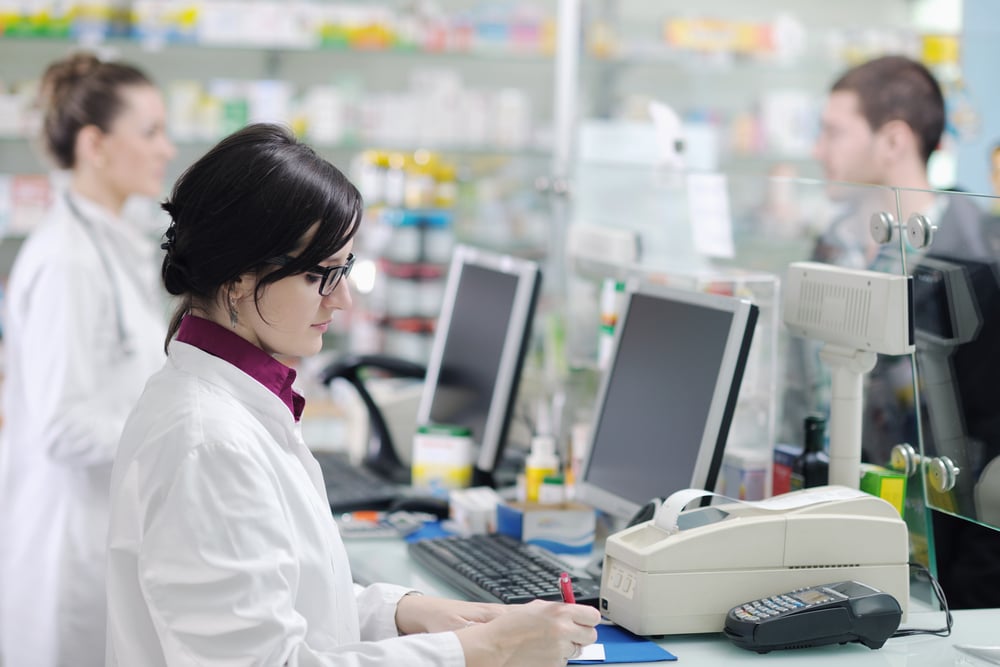 Farmacista elabora una prescrizione digitale al computer in una moderna farmacia. Farmacista elabora una prescrizione digitale al computer in una moderna farmacia.